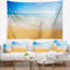 Paysage marin de longues vagues sur le sable sous une tapisserie bleu ciel-28499585