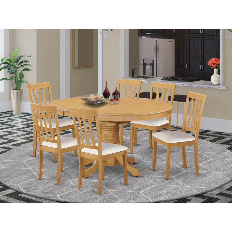 L'ensemble de salle à manger 7 pièces pour 6 personnes comprend une table de cuisine ovale avec rallonge papillon et 4 chaises de cuisine en similicuir, chêne