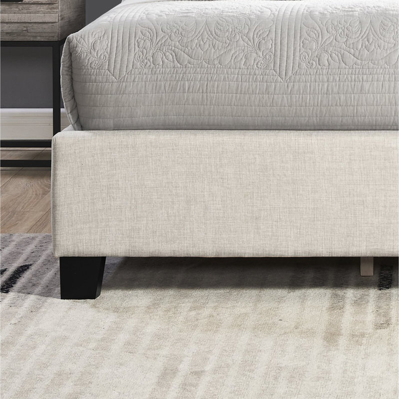 Grand lit beige avec capitonnage à boutons et garniture de tête de lit
