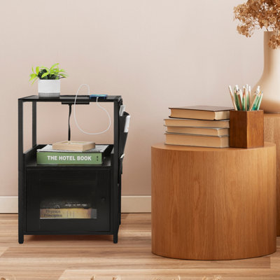 Table de chevet noire avec station de charge, table de chevet moderne avec armoire de porte, poche latérale et tablettes de rangement ouvertes pour la chambre à coucher, le salon