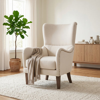 Fauteuil à oreilles rembourré avec garniture cloutée