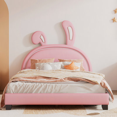 Lit plateforme tapissier en cuir avec ornement en forme de lapin