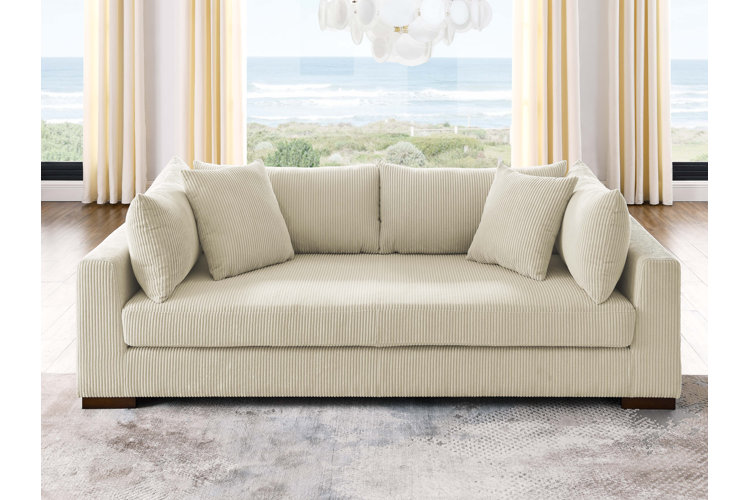 brown leather sofa with a cream-colored throw blanket