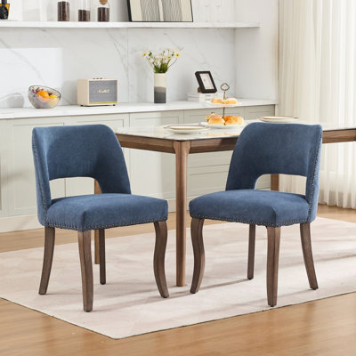 Chaise rembourrée en tissu bleu moderne avec dossier enveloppant, ressorts en S dans un coussin de siège et pieds en bois d'hévéa massif pour les repas, l'assise,