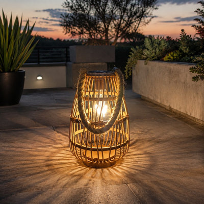 Large waterproof rattan solar lantern with a bright Boho look, Rustic Handle, and Auto On/Off operation; use it hanging or on a tabletop for fence, porch, garden, yard, farmhouse, or wedding decor and as a gift for Mom. For outdoor use.