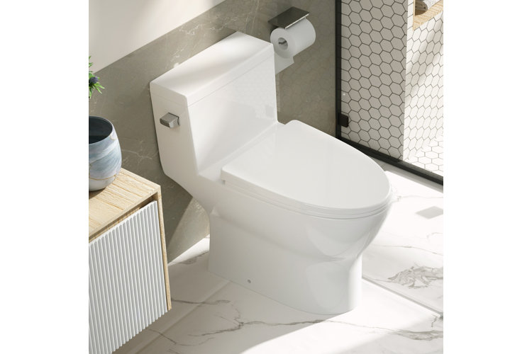 Bathroom with a white elongated toilet, white honeycomb tiles, and white marble floors.