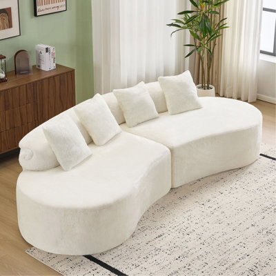 Canapé blanc courbé à plusieurs places. Le tissu moelleux et doux pour la peau en fait un excellent choix pour les décors de salon modernes.
