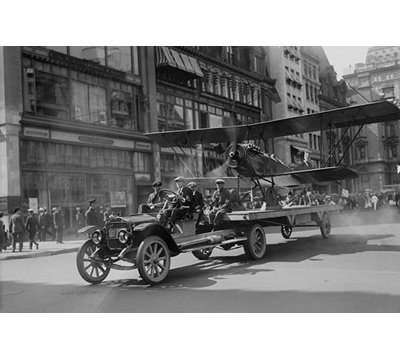 «Biplane with Spinning Propeller is Tow Down Fifth Avenue», reproduction de photo