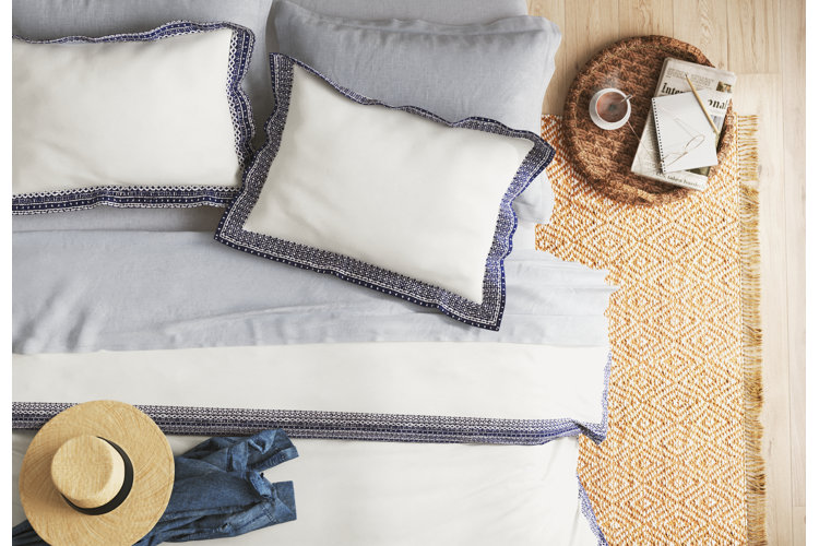 coastal-colored bedding with a jute rug