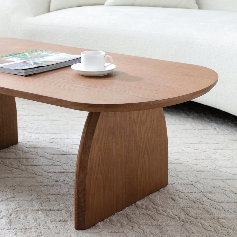 Table basse, piètement incurvé, surface lisse, noyer sélectionné, durabilité à long terme, support ovale en bois massif, répartition uniforme du poids, usage polyvalent
