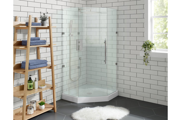 A bathroom with a neo-angle shower pan and a glass shower enclosure in a corner beside a window.