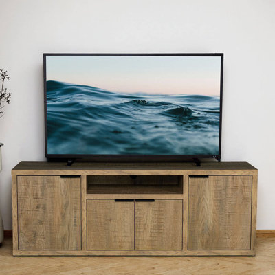 Rehaussez votre espace de vie avec le meuble télé à 4 portes Noriega Mango, un charmant mélange d'élégance rustique et de fonctionnalité moderne.