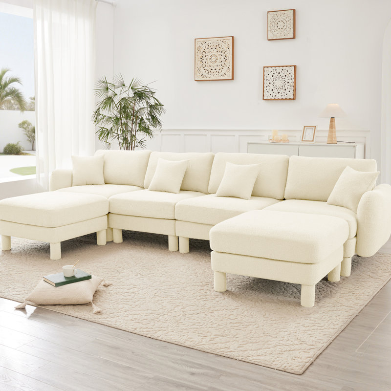 Canapé modulaire en U à 4 places avec revêtement capitonné beige, pieds cylindriques et 2 repose-pieds mobiles pour des rassemblements décontractés. Forme de tissu élégamment courbée et confortable