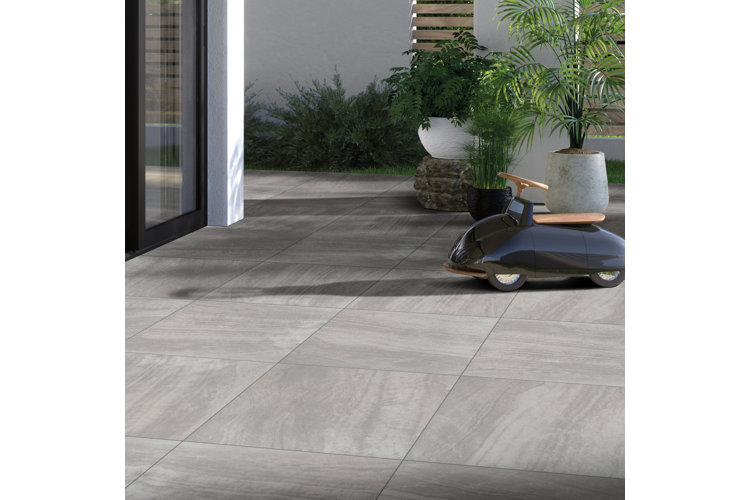Outdoor patio with gray, square-shaped pavers made of stone.