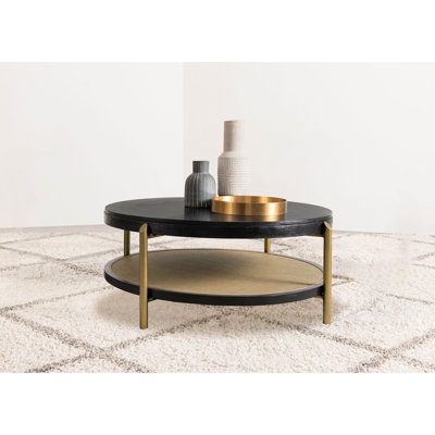 Table basse ronde avec finition noire, tablette de rangement et bois exotique asiatique pour l'aménagement des espaces de vie. Conception double naturelle et pratique.