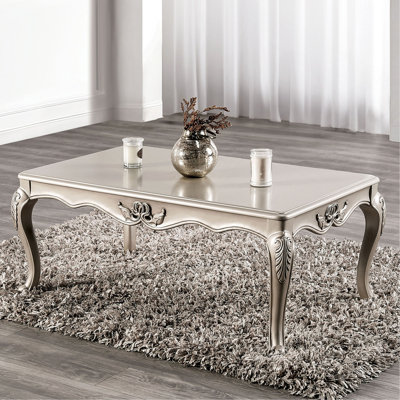 Table basse de style traditionnel avec pieds courbés et structure sculptée en bois massif finition champagne