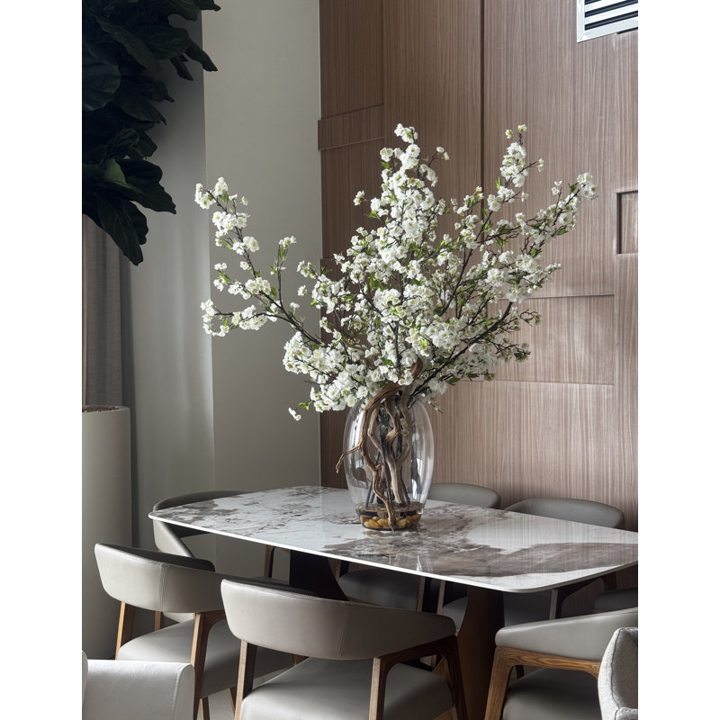 Grandes branches de cerisier en fleurs dans un vase en verre