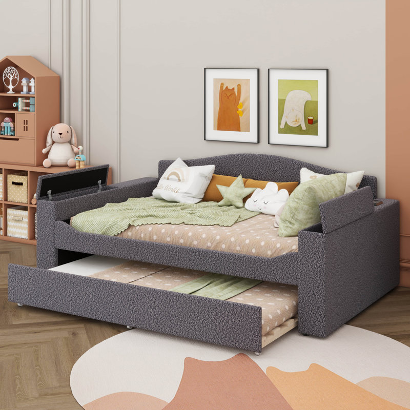 Un lit de jour rembourré avec accoudoirs de rangement, un lit gigogne sous le lit et un système audio Bluetooth de pointe