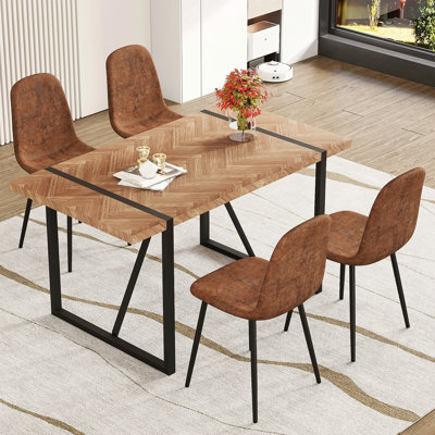 Ensemble de table et de chaises.Une table de salle à manger rectangulaire rétro avec un dessus texturé en arête de poisson de couleur bois et des pieds en métal noir est jumelée à 4 chaises confortables en tissu brun avec des pieds en métal noir.