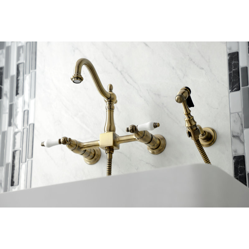 Kingston Brass Heritage Double-Handle 3-Hole Wall-Mount Bridge Kitchen Faucet with Brass Sprayer, Antique Brass