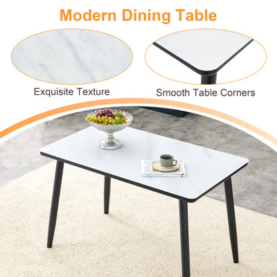 Ensemble de table et de chaises. Plateau en verre imitation marbre blanc + plateau inférieur en panneau de fibres à densité moyenne noir, pieds en métal noir. Combiné avec 4 chaises en plastique transparent avec pieds en métal noir. Apportez une expérience confortable à la maison