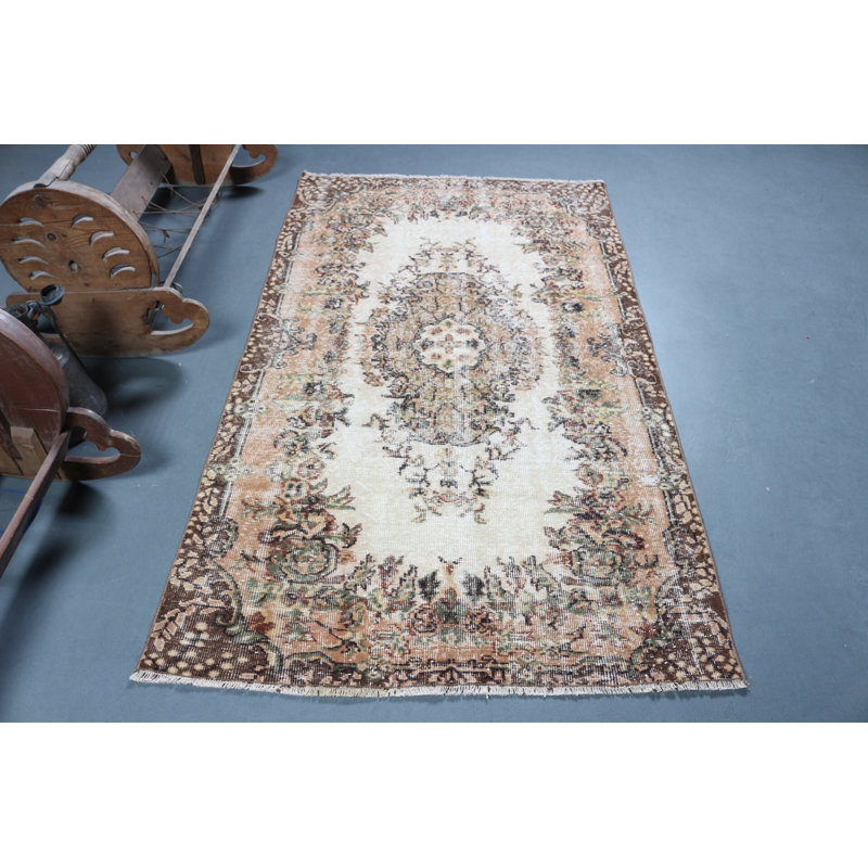 Tapis turc classique classique avec un élégant motif floral dans des tons de terre discrets pour un style de décoration traditionnelle