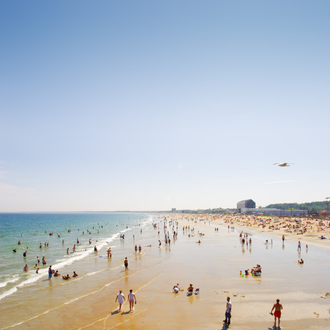 Belebter öffentlicher Strand an einem klaren sonnigen Tag