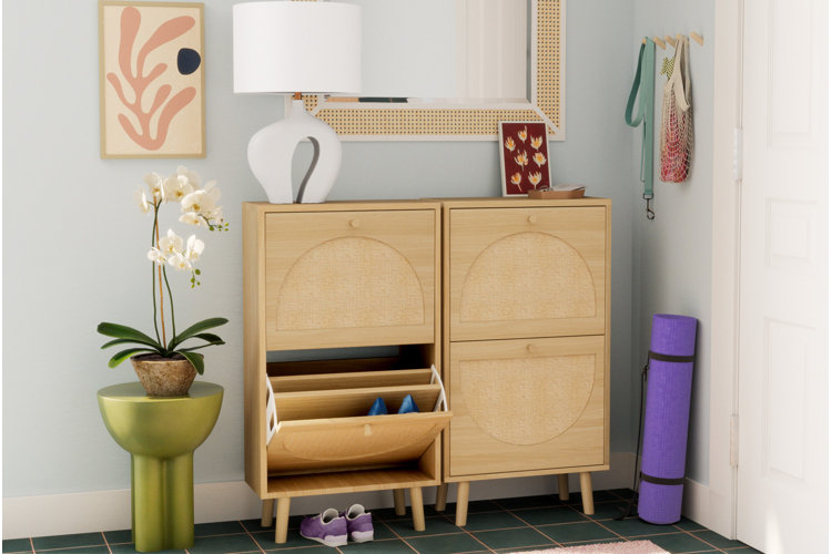 Modern entryway with a light wood shoe storage cabinet with one drawer open to show the amount of shoe storage.