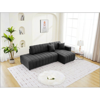 Canapé d'angle capitonné en forme de L avec coussins décoratifs d'inspiration scandinave, parfait pour les intérieurs modernes et minimalistes