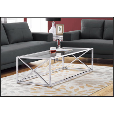 Élégante table basse en verre trempé transparent avec base en métal chromé, parfaite pour les salons modernes et spacieux.