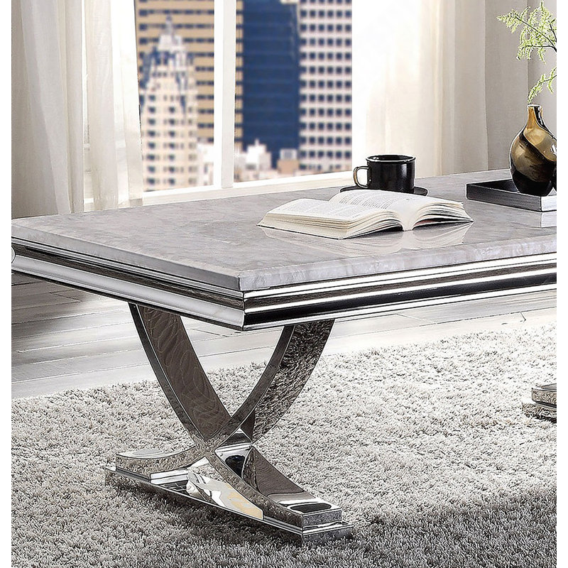 Table basse moderne de style glamour avec plateau en faux marbre et base piédestal chromée, parfaite pour les espaces de vie luxueux.