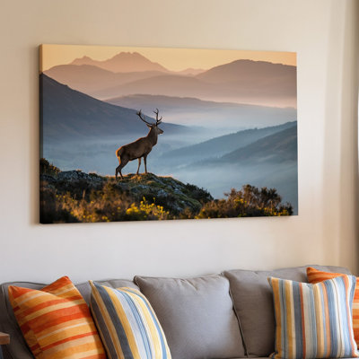 Canvas A Majestic Stag Stands Proudly On A Rocky Outcrop Surrounded Wall Art By A Breathtaking Landscape Of Layered Mountains Shrouded Canvas Wall Art
