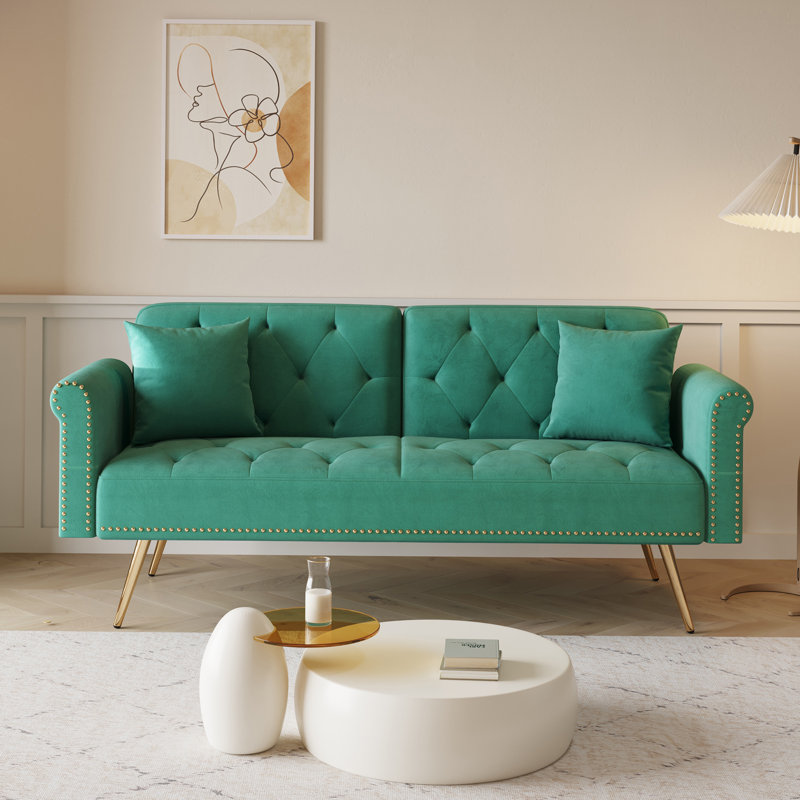 Luxueux canapé-lit en velours vert avec garniture cloutée et coussin décoratif assorti, pour plus de confort et de style