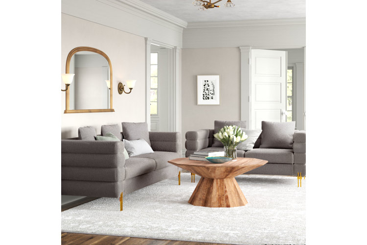 modern glam living room with gray sofas, light wood coffee table, white rug, and gold framed mirror