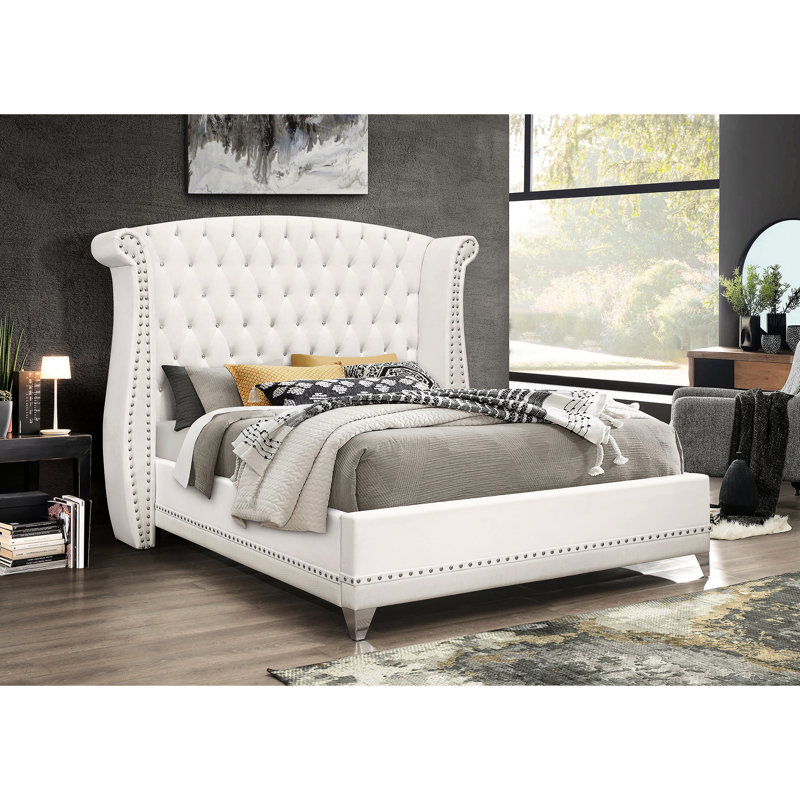 Lit à oreilles tapissier très grand en velours blanc avec tête de lit dramatique et détails pour la chambre à coucher avec revêtement, tête de lit haute, garniture cloutée