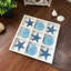 Jeu de morpion côtier avec pièces en bois blanchi et en résine bleue représentant la mer, 29,8 cm de large