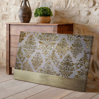 La toile crée un design de papier peint élégant avec un motif damassé complexe en or chatoyant contre un taupe doux