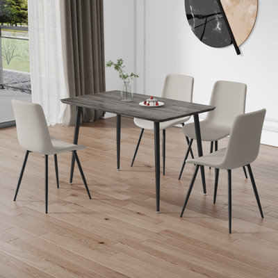 Ensemble de table de salle à manger et de chaises de style industriel, table en bois aggloméré gris avec pieds en fer noir et 4 chaises en polyuréthane gris clair avec coussins courbés