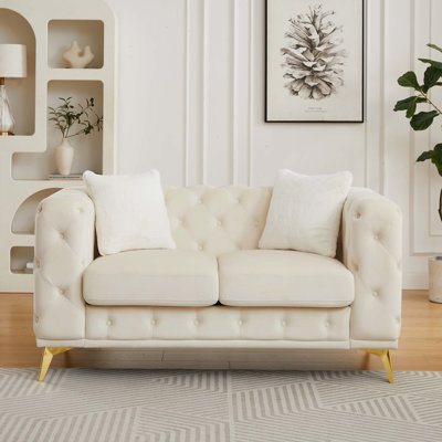 Luxueux canapé Chesterfield en velours avec un design capitonné et une structure durable pour un confort de salon élégant.
