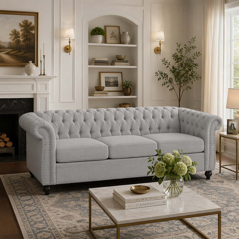 Canapé 3 places de style Chesterfield avec capitonnage à boutons, clous décoratifs et accoudoirs sculptés pour des espaces de vie élégants.
