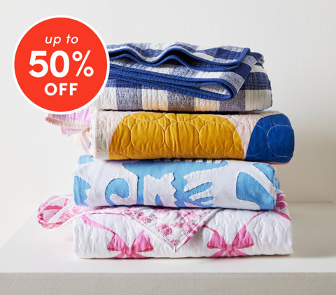 Bedding and sheet sets up to 50% off featuring colorful folded quilts and blankets