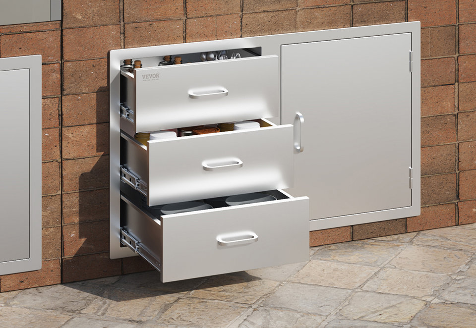 Stainless steel outdoor kitchen storage unit with three drawers and a side access door installed in a brick island.