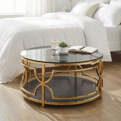 Table basse ronde en verre trempé avec structure géométrique en métal et tablette inférieure en finition noire et dorée