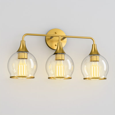 Applique murale réversible à 3 lumières, fini or brossé, avec abat-jour en verre transparent et globe lumineux.