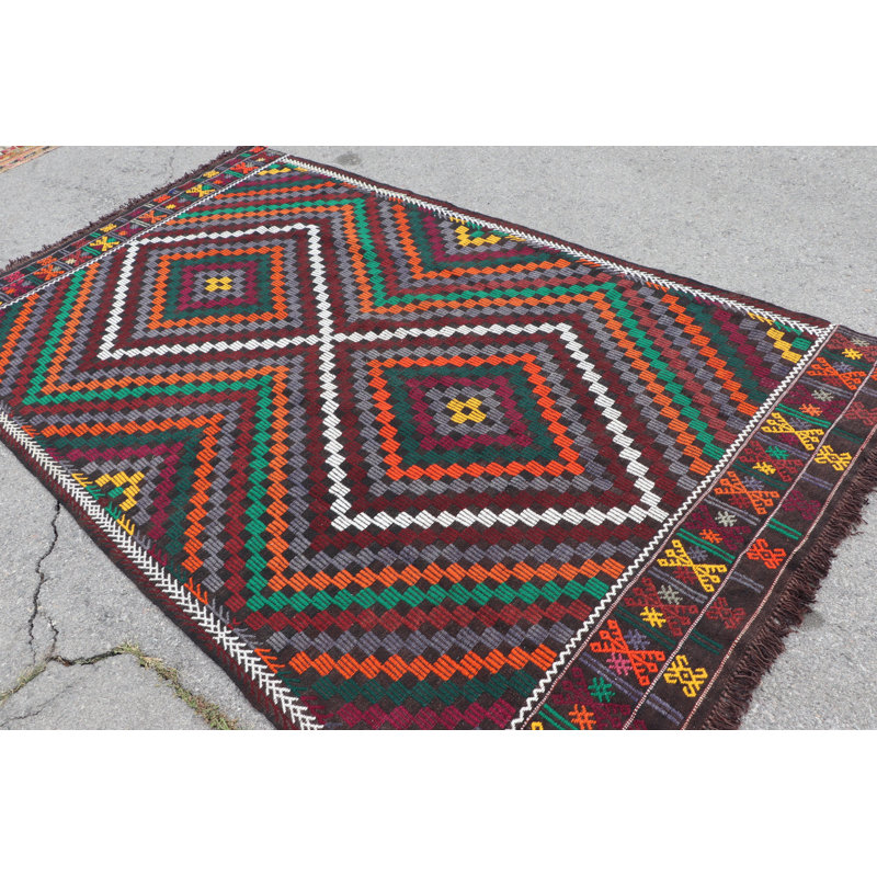 Tapis turc vibrant fabriqué à la main dans des motifs géométriques rouge, vert et orange pour un décor traditionnel