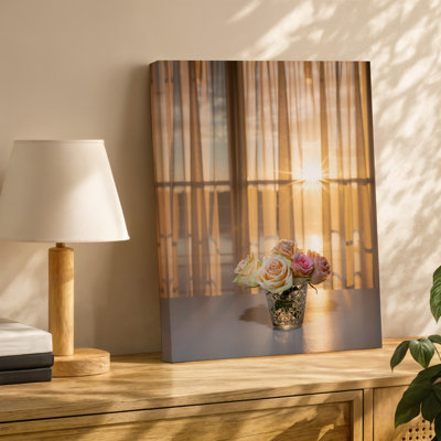 Toile, une scène intérieure sereine au coucher du soleil avec un vase délicat, rempli de roses crème crémeuses positionnées sur une toile murale minimaliste