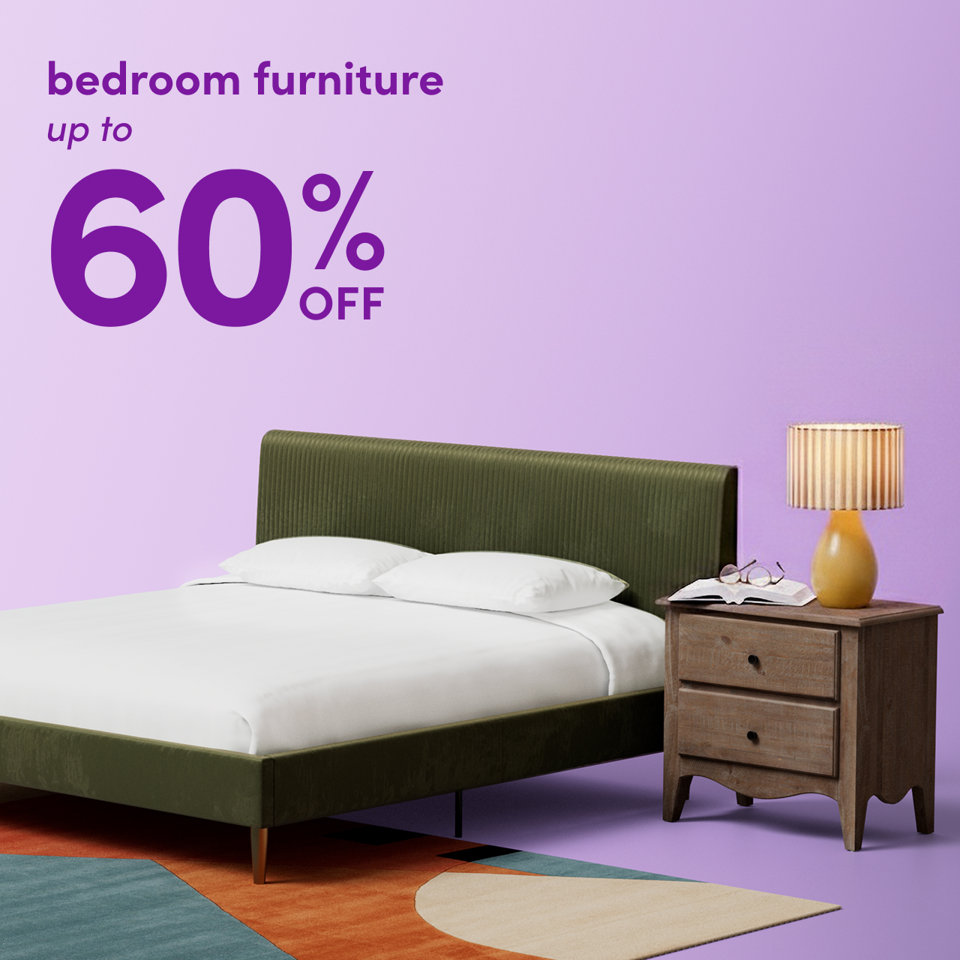 Bedroom furniture up to 60 percent off featuring a green upholstered bed, wooden nightstand, and yellow lamp on a colorful patterned rug against a purple background.
