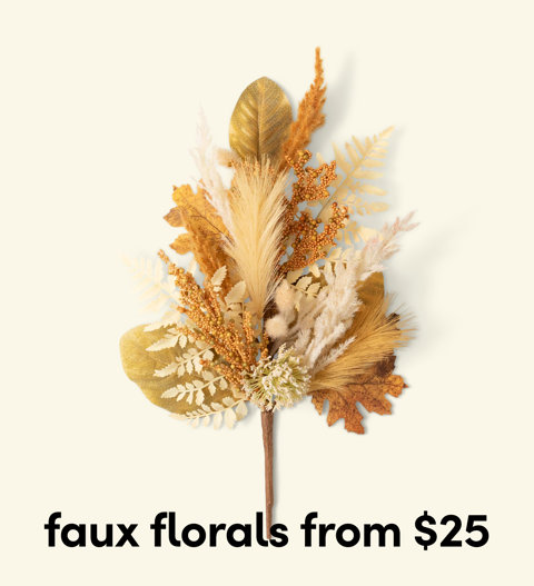 A decorative arrangement of autumn-toned faux florals, pampas grass, and dried leaves, with the text faux florals from $25 below.
