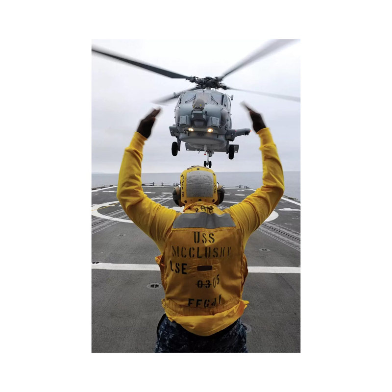 Petty Officer Guides An SH-60R Sea Hawk Helicopter Onto The Flight Deck Of USS McClusky - Wrapped Canvas Print