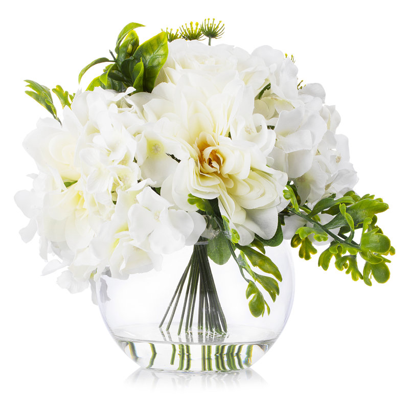 Crème hydrangées roses et pivoines mélangées en soie dans un vase rond en verre transparent